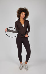 Black ankle-length leggings with a high waistband and side pocket, paired with a matching fitted zip-up top, worn with.