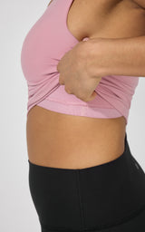 Pink fitted tank top with built-in bra detail paired with high-waist black leggings.