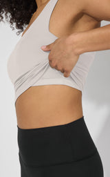 Light beige tank top with built-in bra detail worn with high-waisted black leggings.