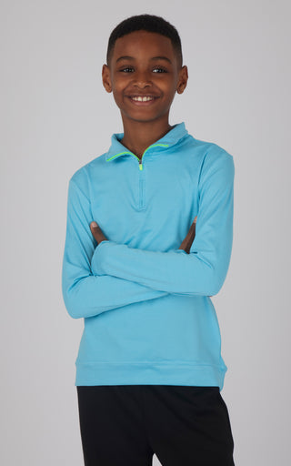 A boy wearing a blue quarter zip pullover sweatshirt with the zipper open and arms crossed.