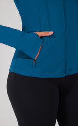 Blue topaz full zip runner jacket with thumb hole cuff and side pocket zipper detail.