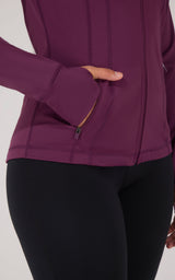 Purple full zip runner jacket with zippered pockets and fitted cuffs.