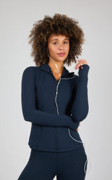 Dark navy full zip runner jacket with a high collar, fitted long sleeves, and smooth fabric on a female model.