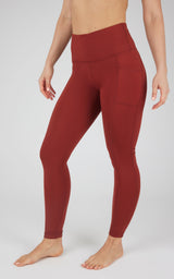 High-waist fleece-lined leggings in deep red with side pockets and a smooth, fitted silhouette.