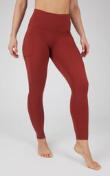 High-waist rust red fleece-lined leggings with side pockets and smooth, stretchy fabric.