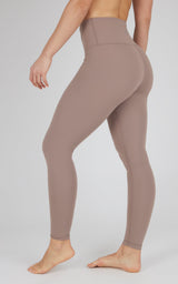 Full-length nude tech leggings with high waistband and smooth, stretchy fabric on model's legs and hips.