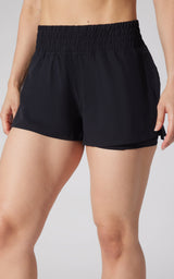Black lightweight running shorts with elastic waistband and relaxed fit on woman.