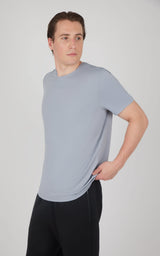Men’s short sleeve t-shirt in light gray with a crew neck, paired with black pants.