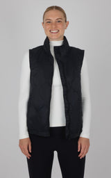 Black quilted sleeveless vest with high collar, worn over white long-sleeve top.