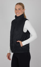 Black quilted sleeveless vest with high collar and side pockets, worn over white long-sleeve shirt.