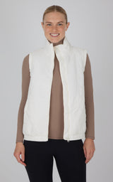 White quilted sleeveless vest with high collar, front zipper, worn over long-sleeve beige top.
