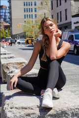 Black high-waisted Power Flex leggings with a subtle texture, paired with white sneakers.