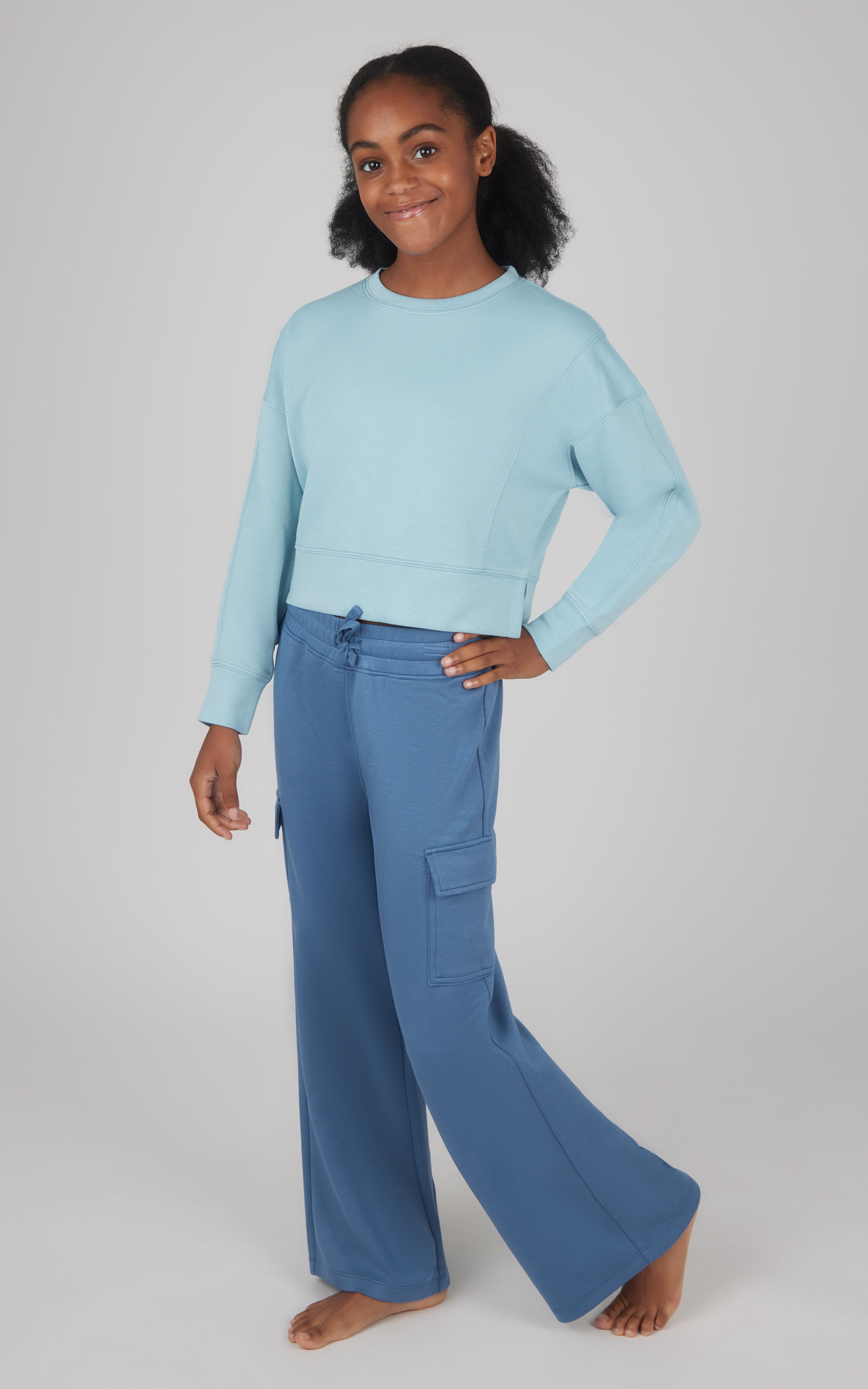Girls softlite light blue cropped pullover with long sleeves and blue wide-leg cargo pants with side pockets.