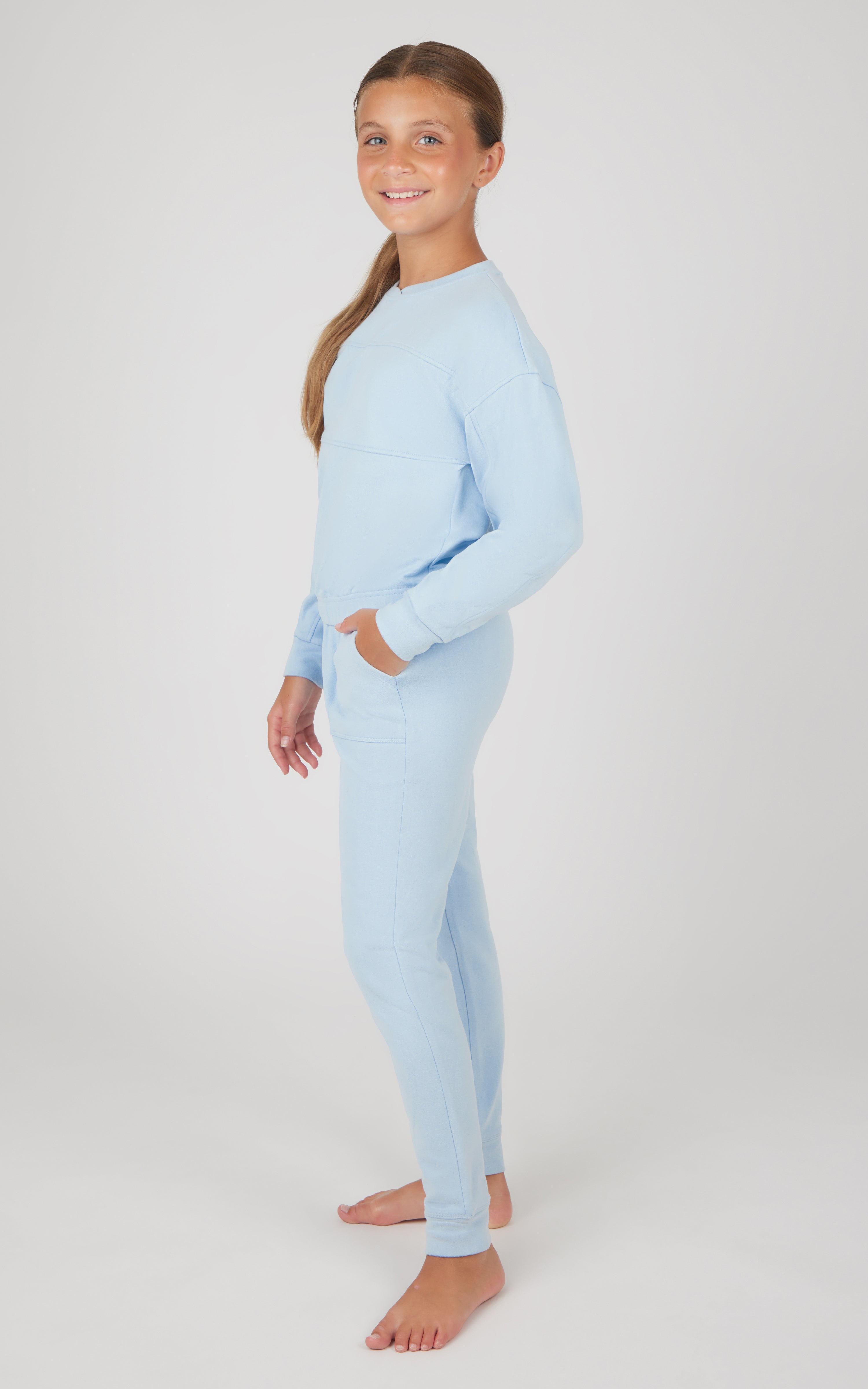 Girl wearing light blue melange long sleeve top and matching jogger pants set, fitted style.