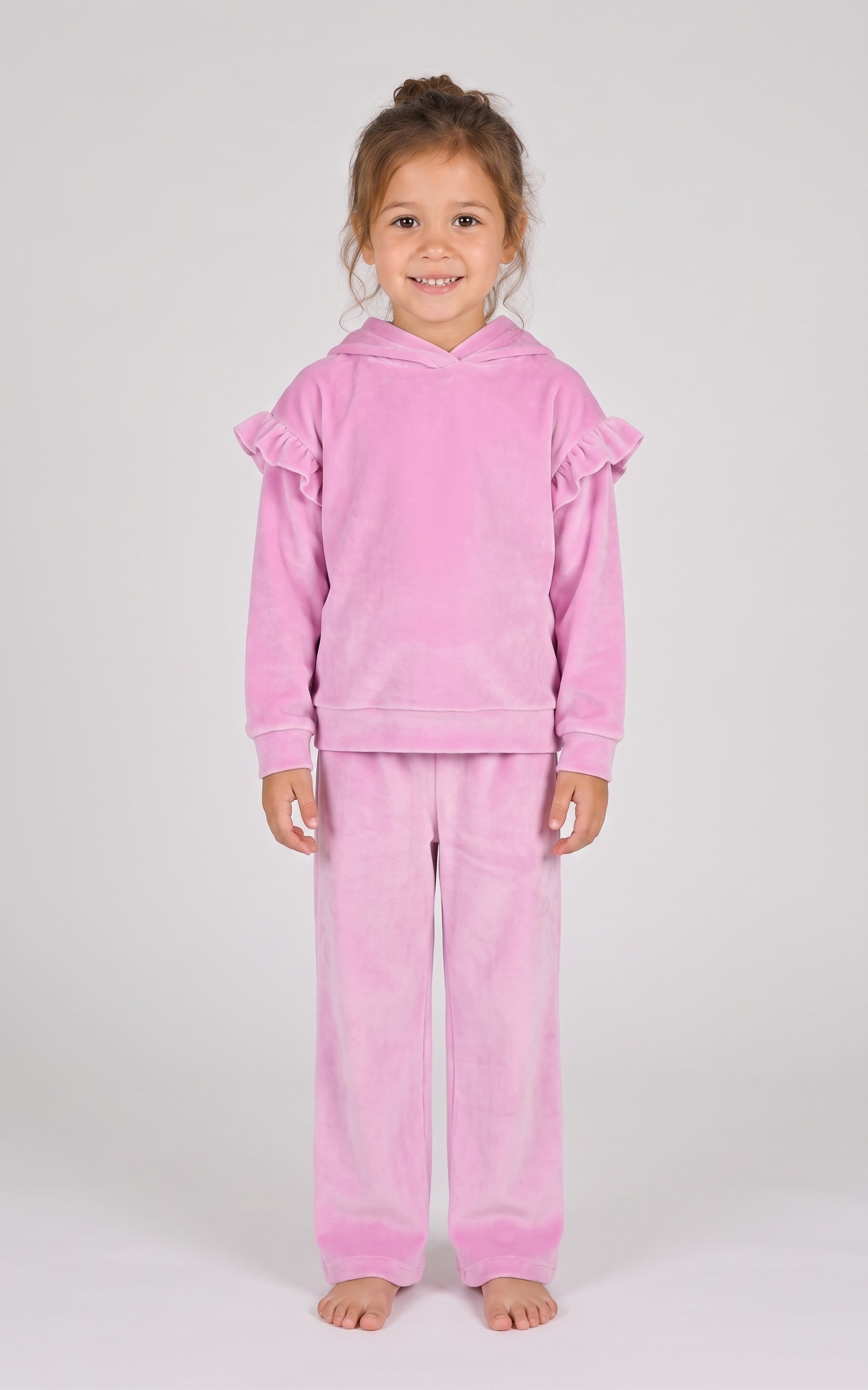 Little girl wearing fuchsia pink velour pullover hoodie with ruffle sleeves and matching flare pants.