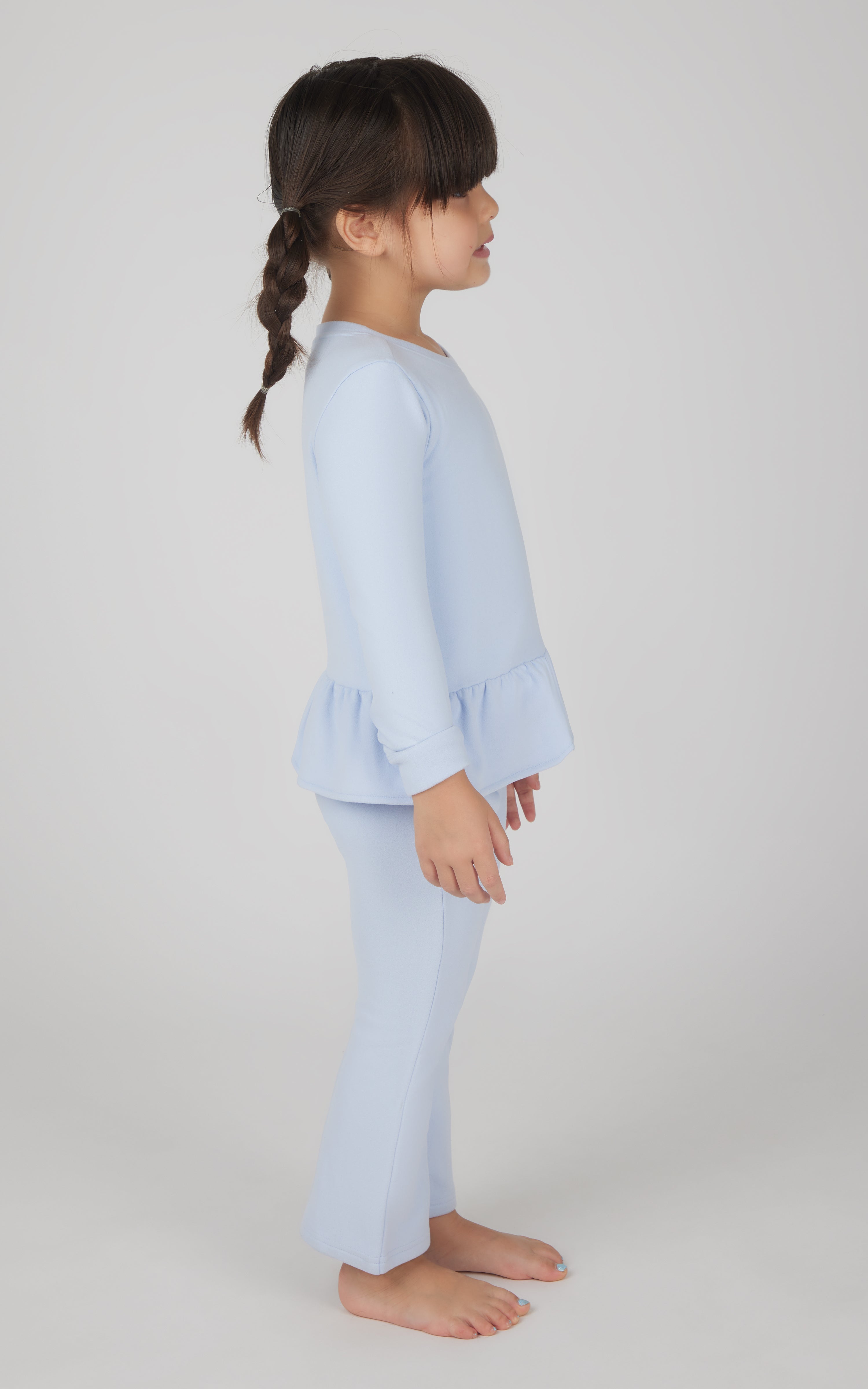 Toddler girl in light blue melange pullover with flare hem and matching flare leg pants.