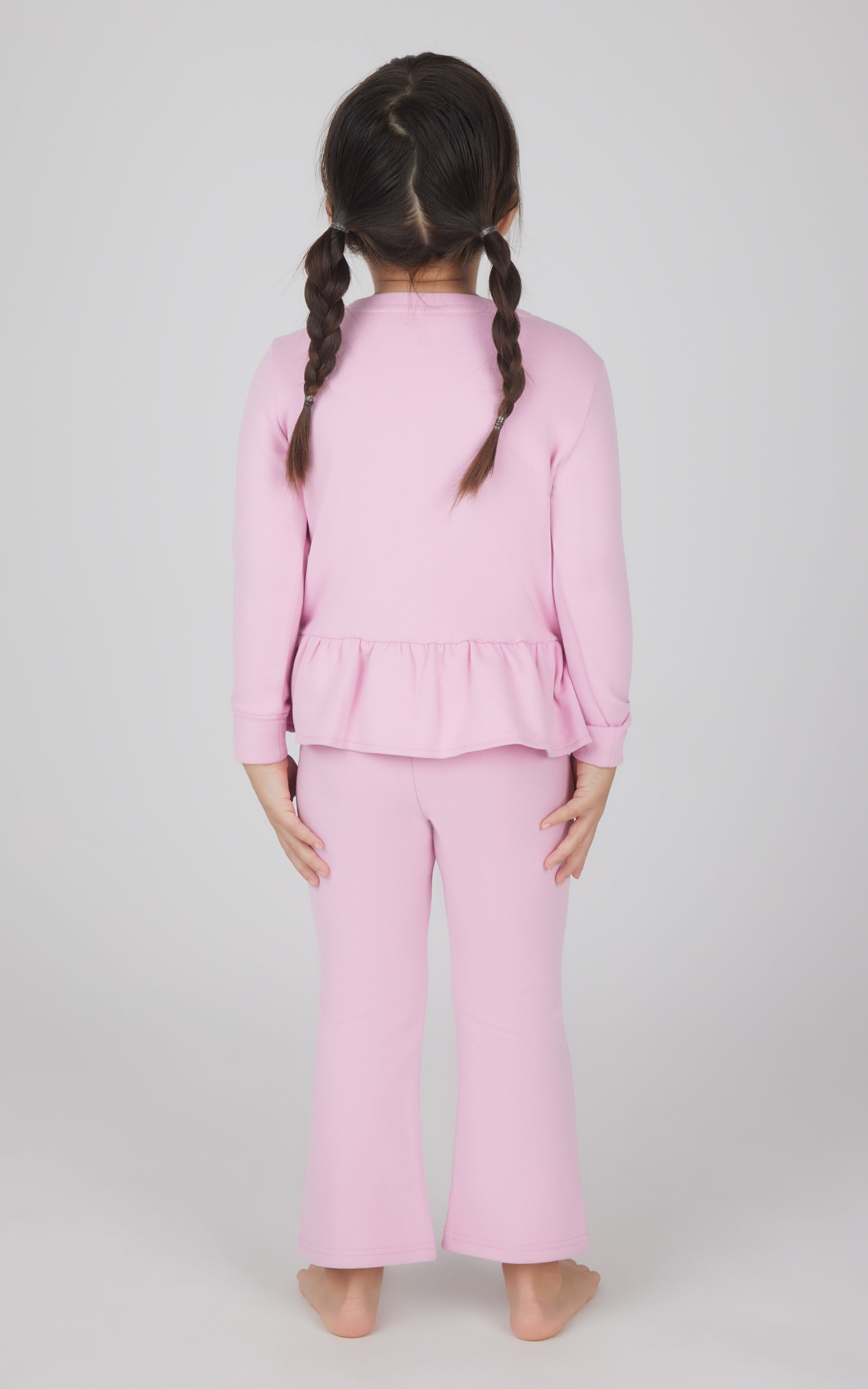 Toddler girls' pink melange pullover with peplum hem and matching flare leg pants, back view.