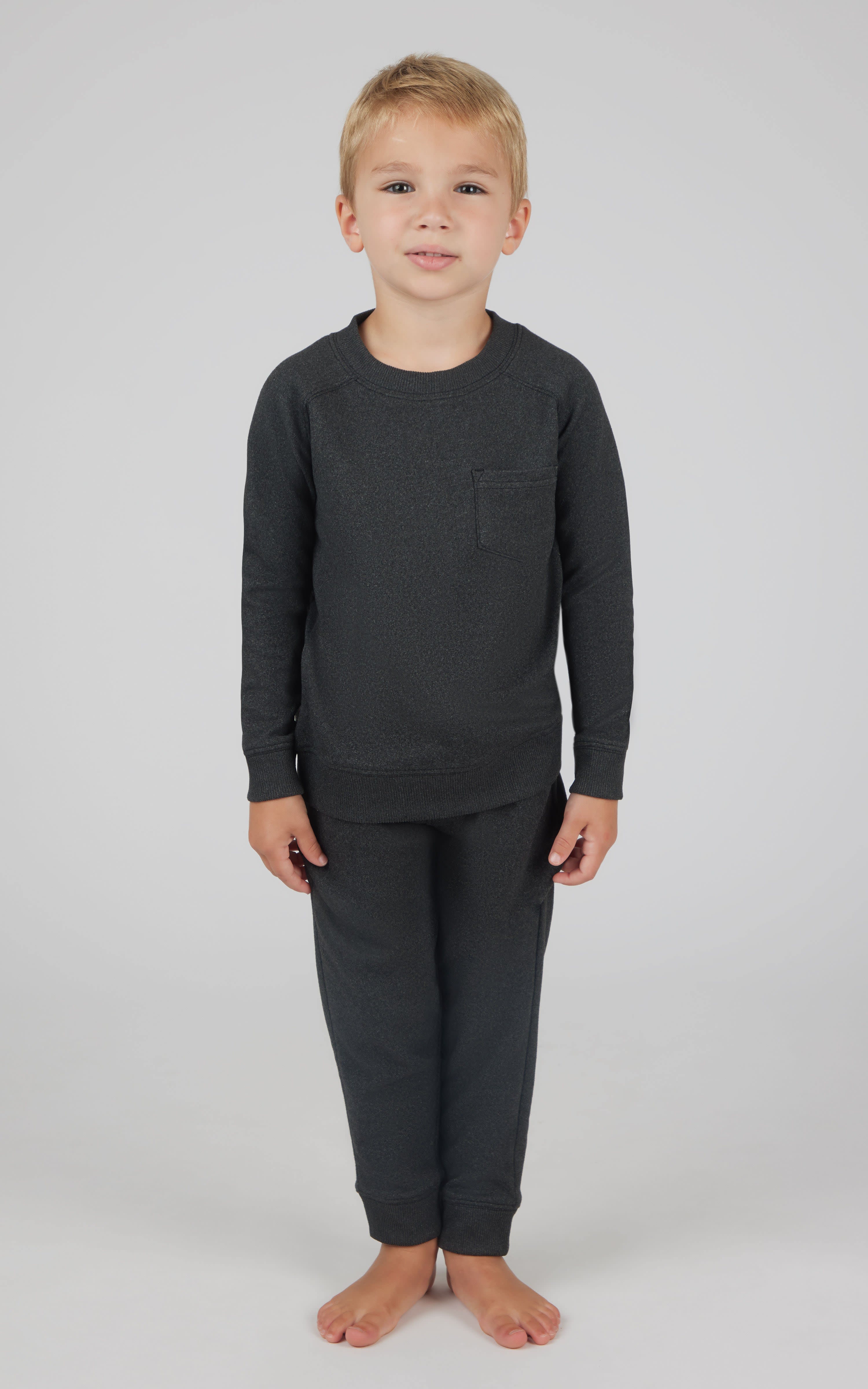 Toddler boy wearing black fleece sweatshirt with chest pocket and matching joggers.