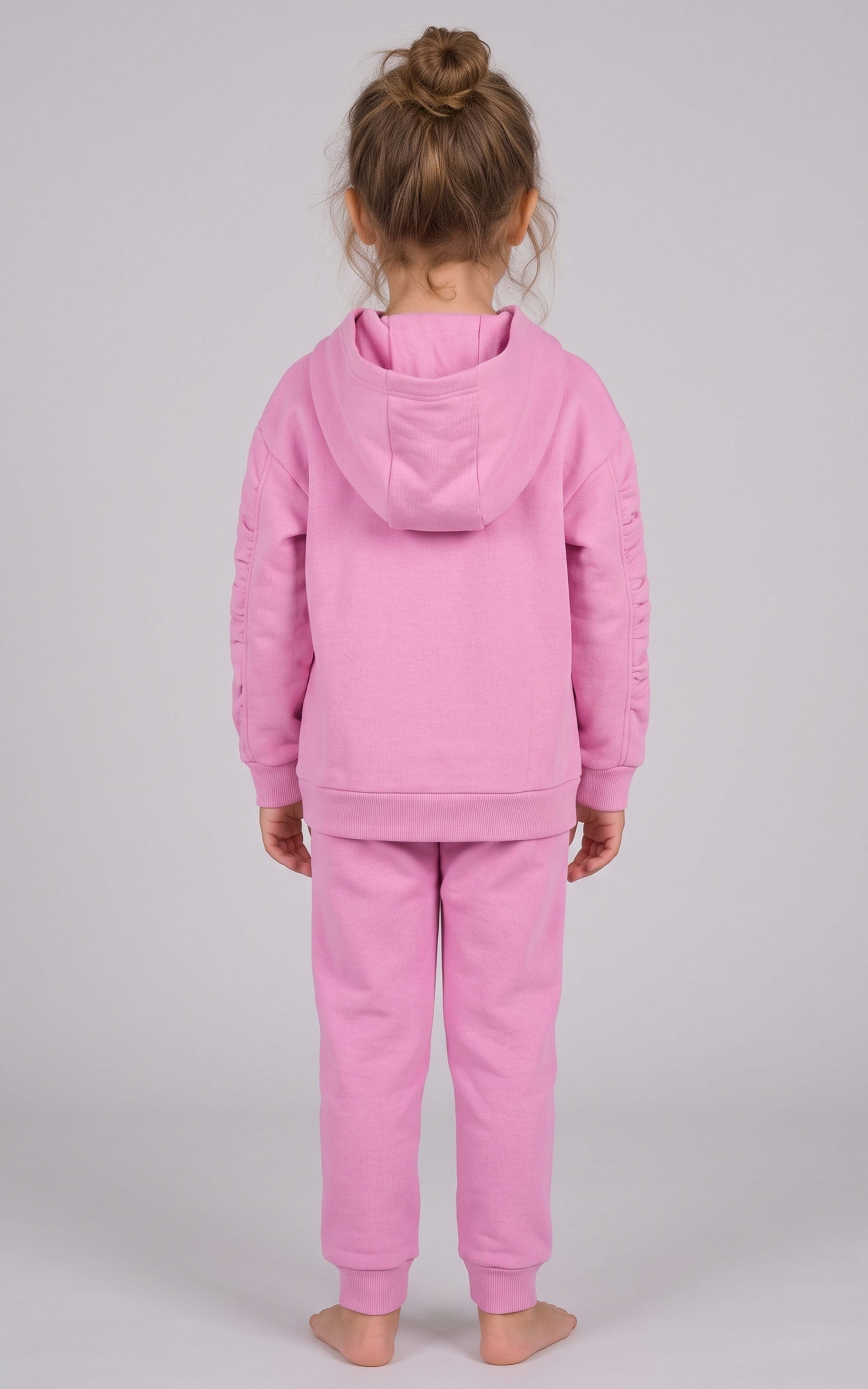 Toddler wearing a pink brushed-terry hoodie and tapered joggers, shown from behind with the hood down.