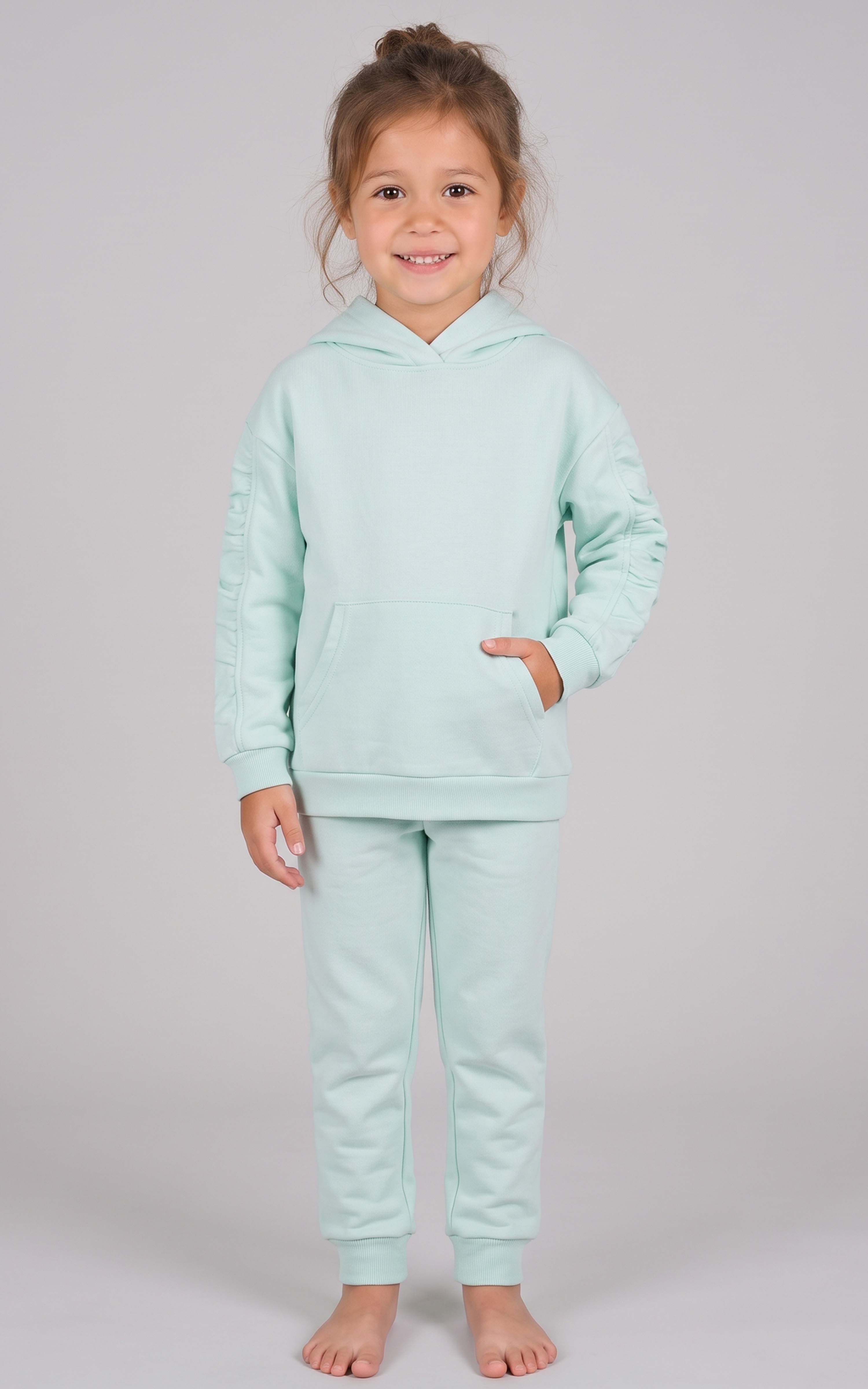 Toddler wearing a mint green brushed terry hoodie and tapered joggers with a front pocket.