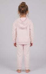 Back view of a toddler girl wearing a pale pink brushed terry hoodie and tapered joggers set.