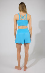 Bubble blue strappy back sports bra with matching high-waisted running shorts.