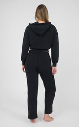 Black women’s matching set with a cropped hooded jacket and relaxed straight-leg pants, shown from the back.