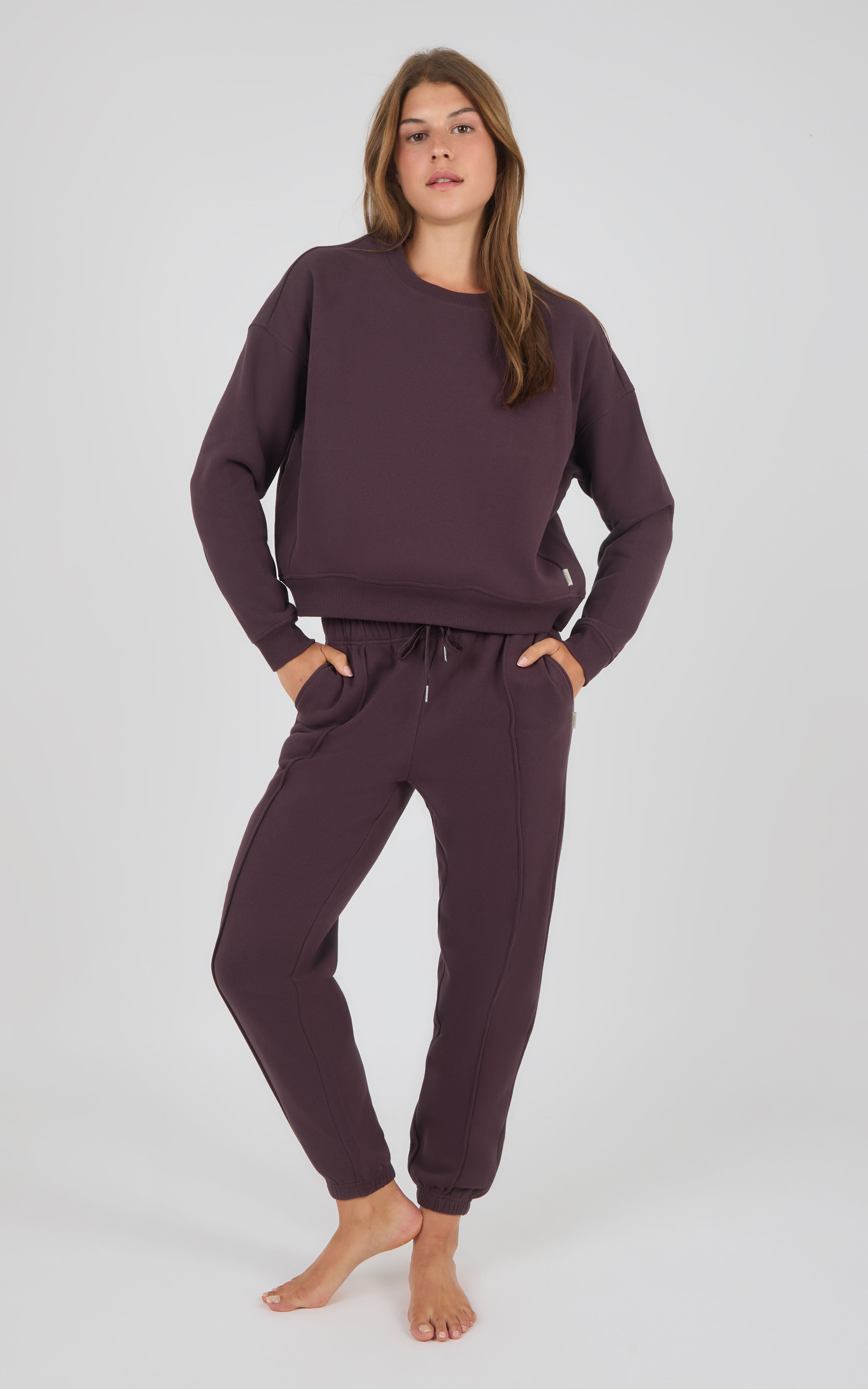 Dark berry oversized sweatshirt paired with matching pintuck jogger pants with drawstring waistband and cuffed ankles.