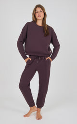 Dark berry oversized sweatshirt paired with matching pintuck jogger pants with drawstring waistband and cuffed ankles.