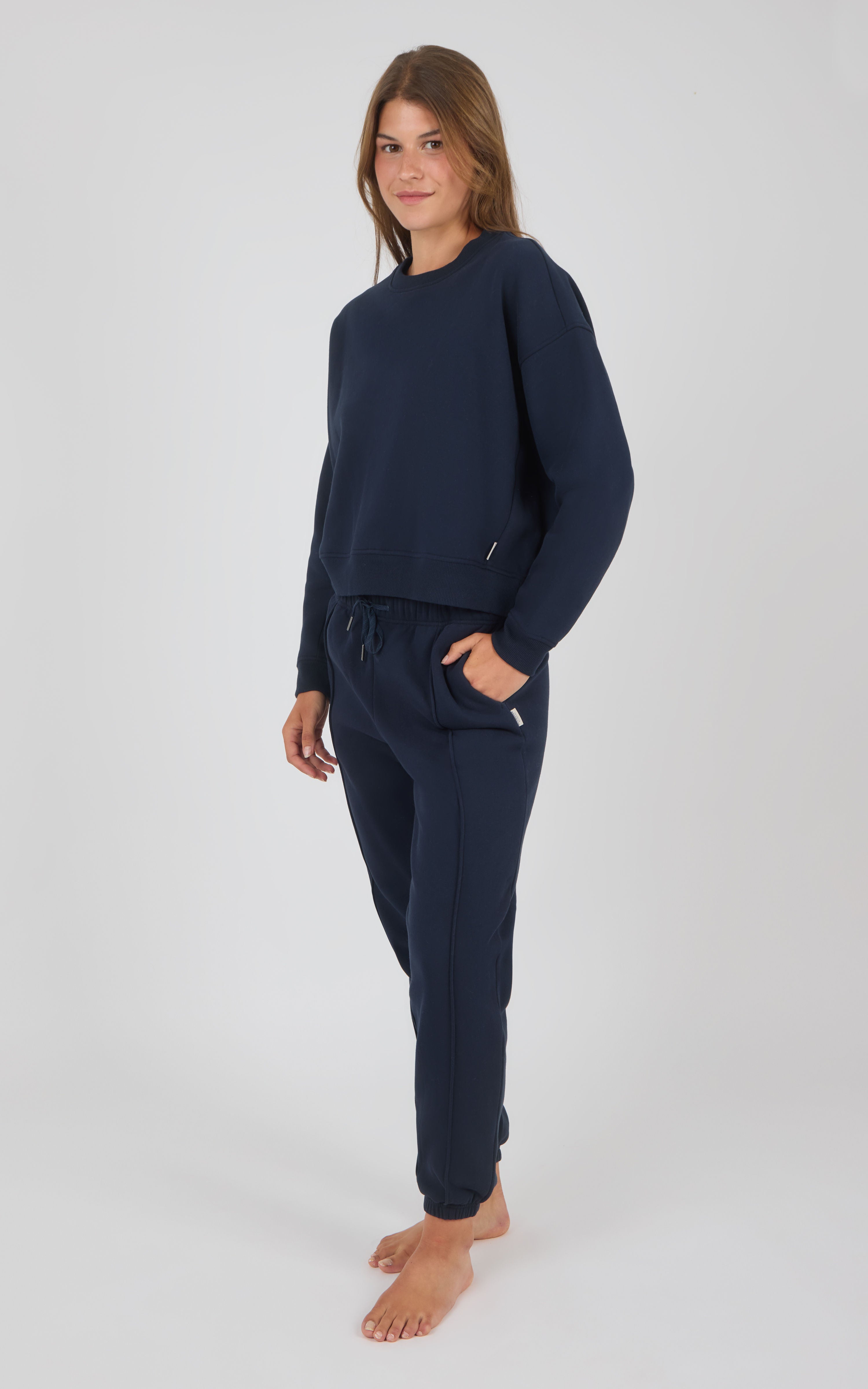 Woman wearing navy blue long-sleeve pullover and matching pintuck jogger pants with pockets.