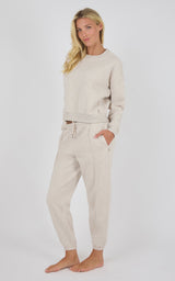Beige long-sleeve knit top with matching pintuck jogger pants, relaxed fit, drawstring waist.