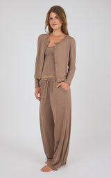 A woman modeling a matching lounge set consisting of a taupe cardigan, tank top, and drawstring pants against a light gray studio background.