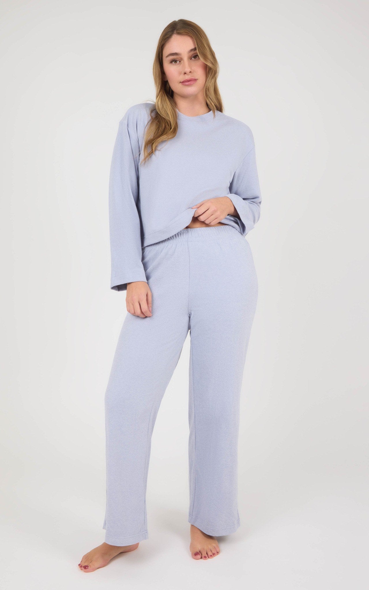Woman modeling a light lavender marled lounge set with a boxy long-sleeve top and straight-leg pants.
