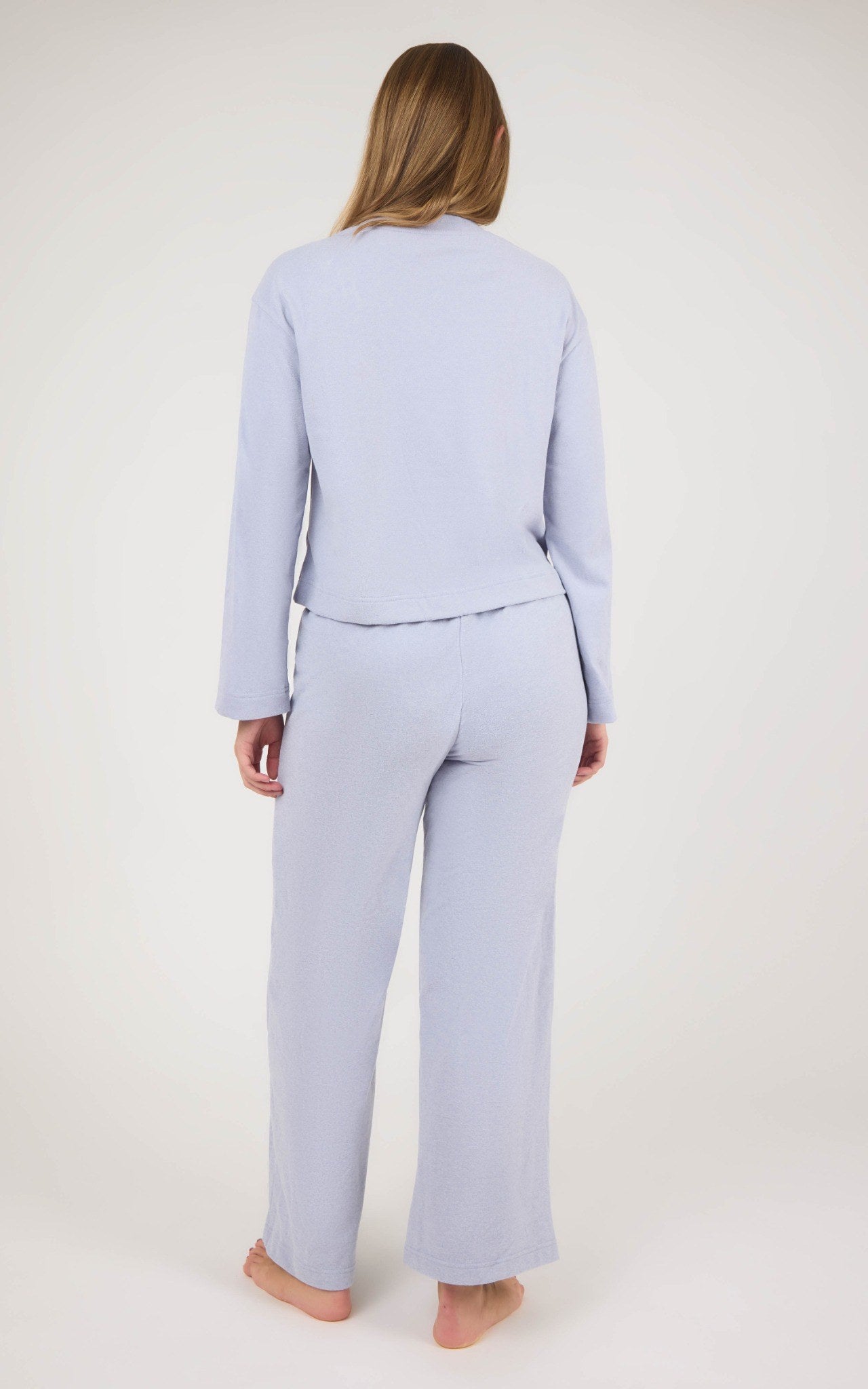 Back view of a light lavender marled knit set with a cropped long-sleeve top and straight-leg pants.