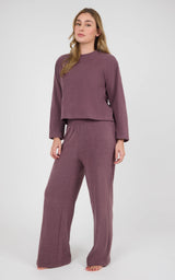 Woman wearing a mauve marled knit set with a boxy cropped long-sleeve top and wide-leg pants.