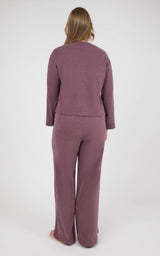 Back view of a woman wearing a mauve marled knit set with a boxy long-sleeve top and straight-leg pants.