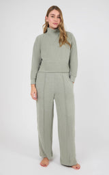 Woman wearing a sage gray marled knit pullover with raglan sleeves and matching pintuck wide-leg pants.