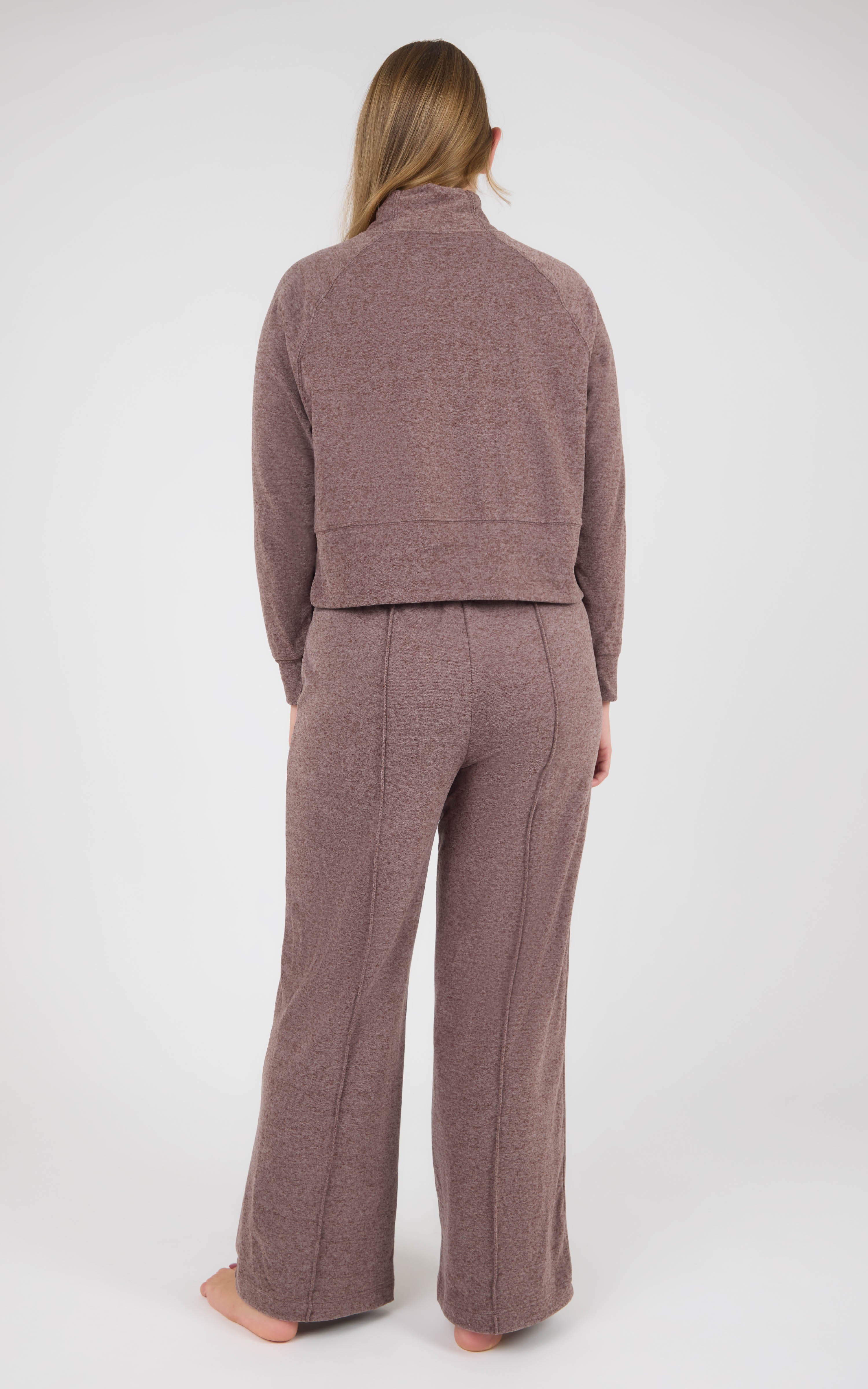 Back view of a woman wearing a dusty mauve marled knit pullover and matching wide-leg pants.