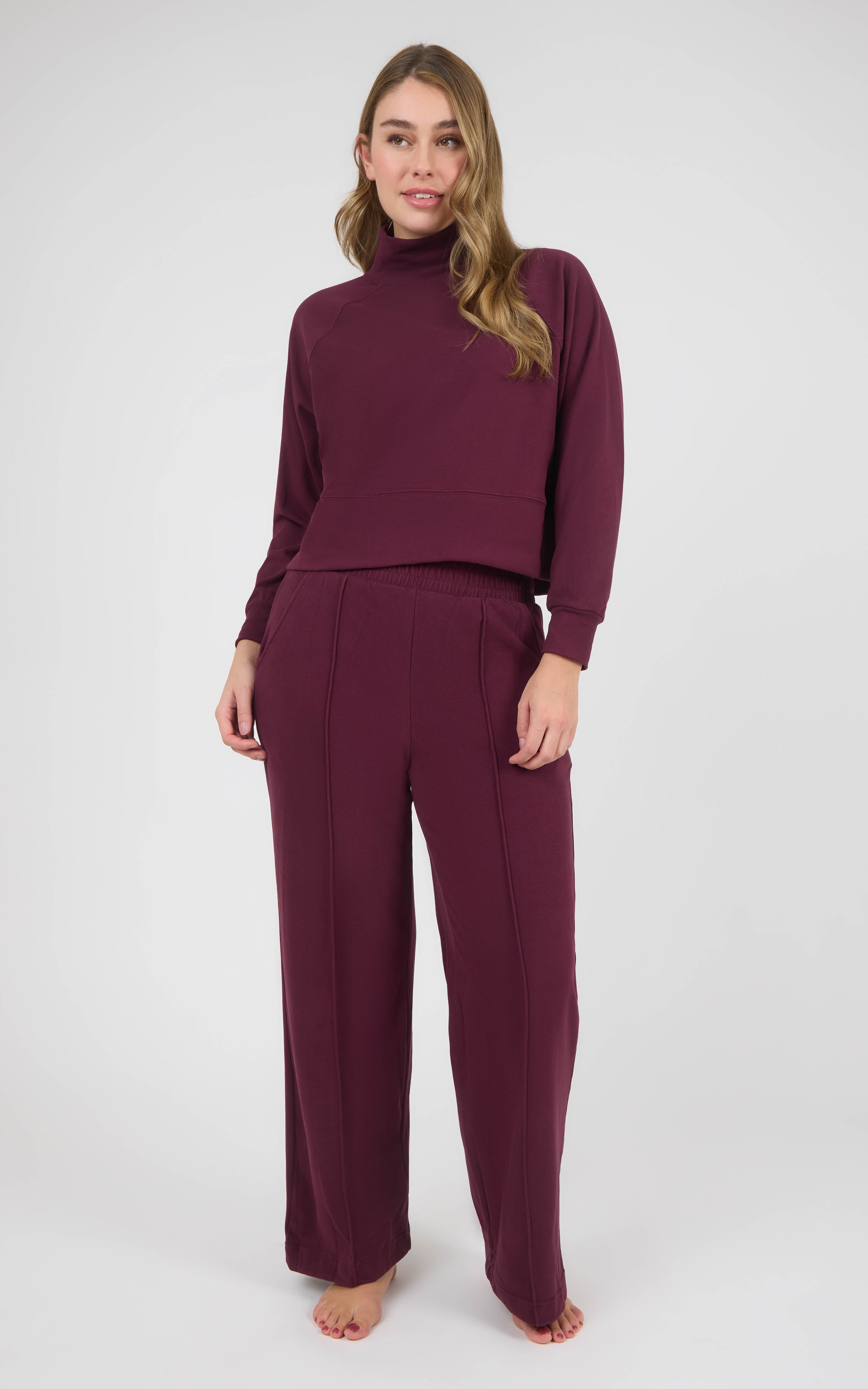 Model wearing a burgundy marled pique raglan pullover and matching pintuck wide-leg pants.