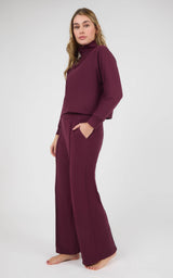 Woman wearing a burgundy long-sleeve pullover and matching wide-leg pants in marled pique fabric.