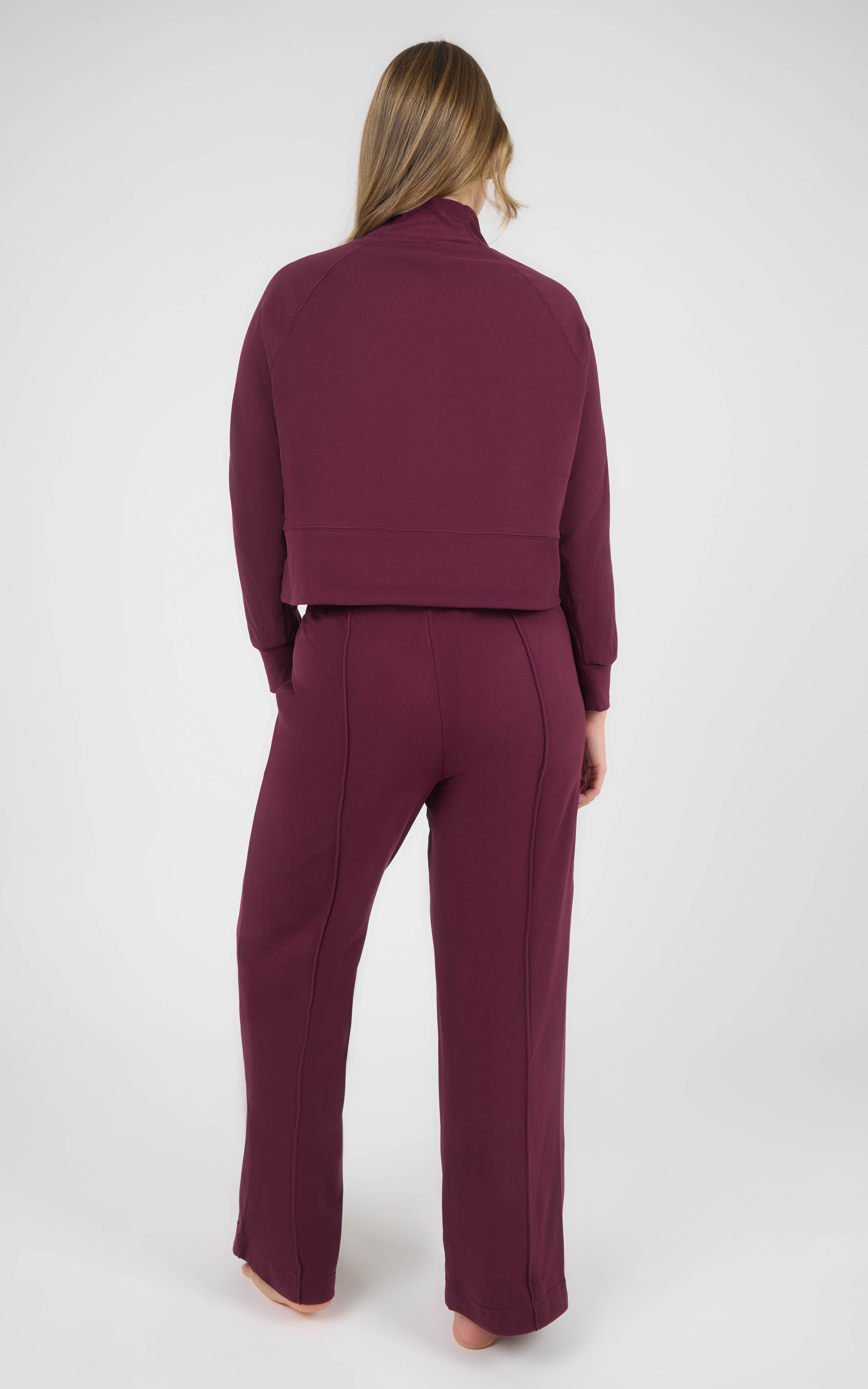 Back view of a burgundy marled pique lounge set with a long-sleeve pullover and straight wide-leg pants.