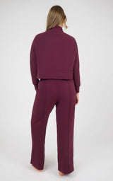 Back view of a burgundy marled pique lounge set with a long-sleeve pullover and straight wide-leg pants.