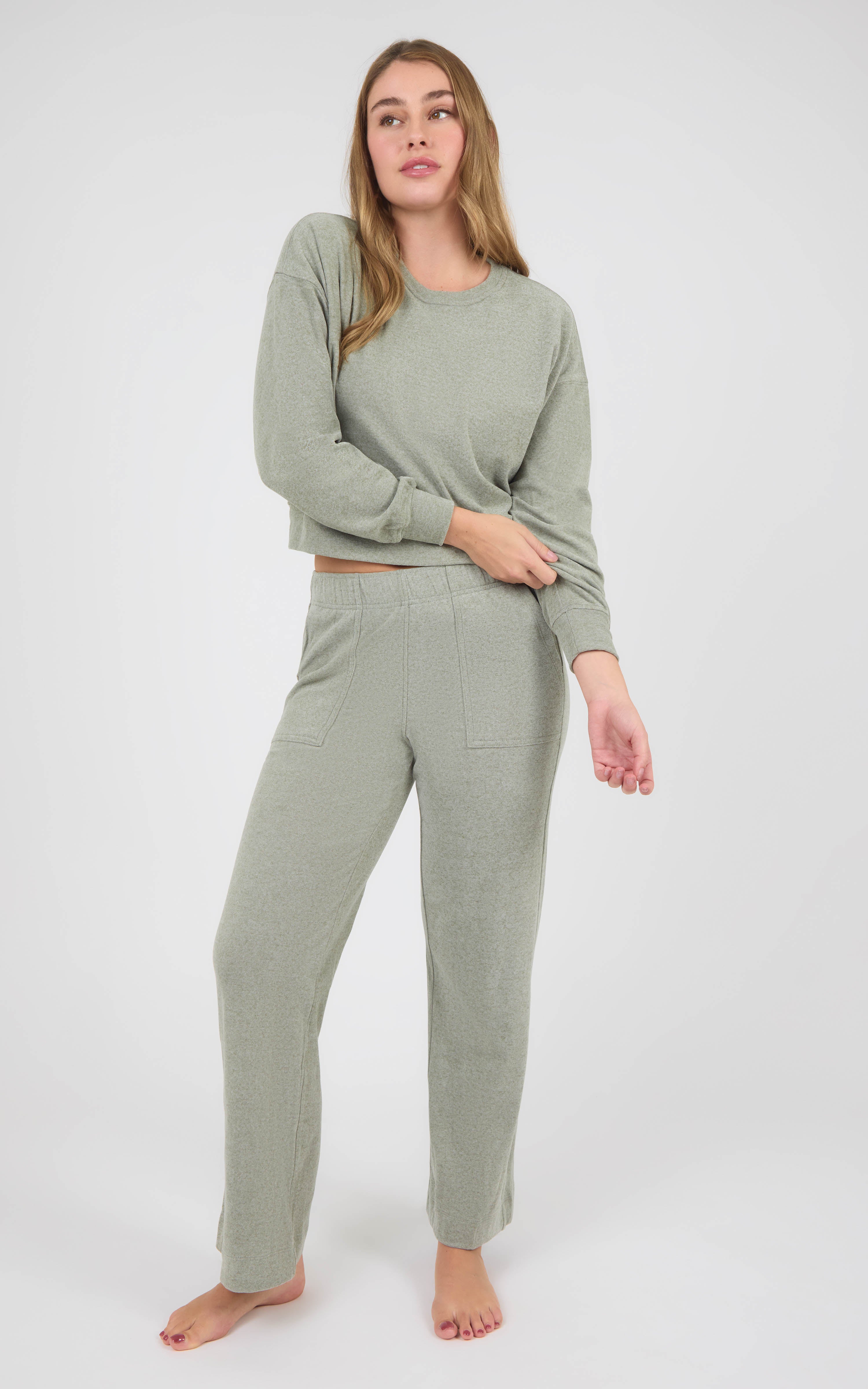 Woman wearing a sage gray marled long-sleeve crewneck pullover and matching wide-leg pants with side pockets.
