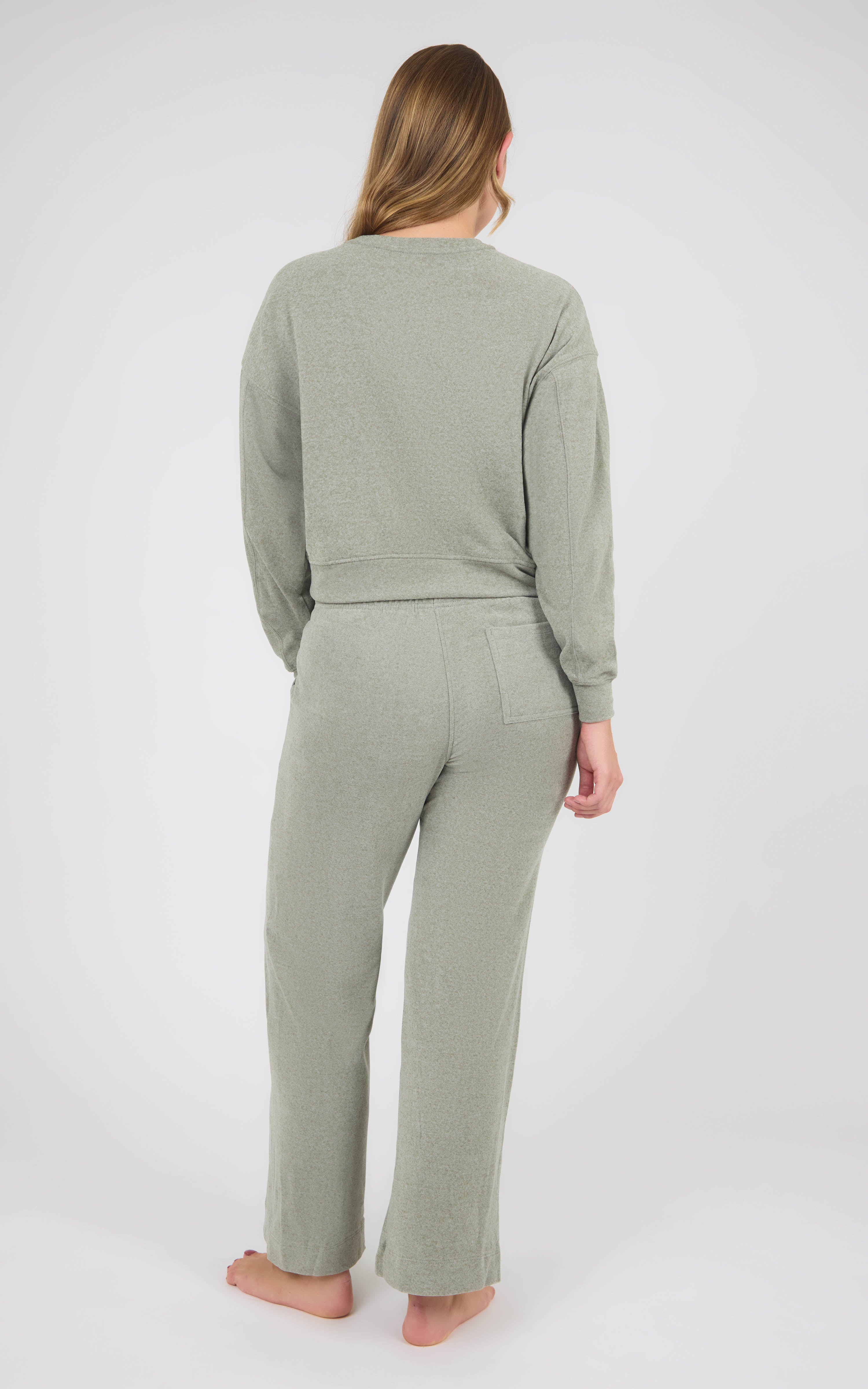 Woman wearing a sage gray marled knit set with a long-sleeve crewneck top and wide-leg pants.