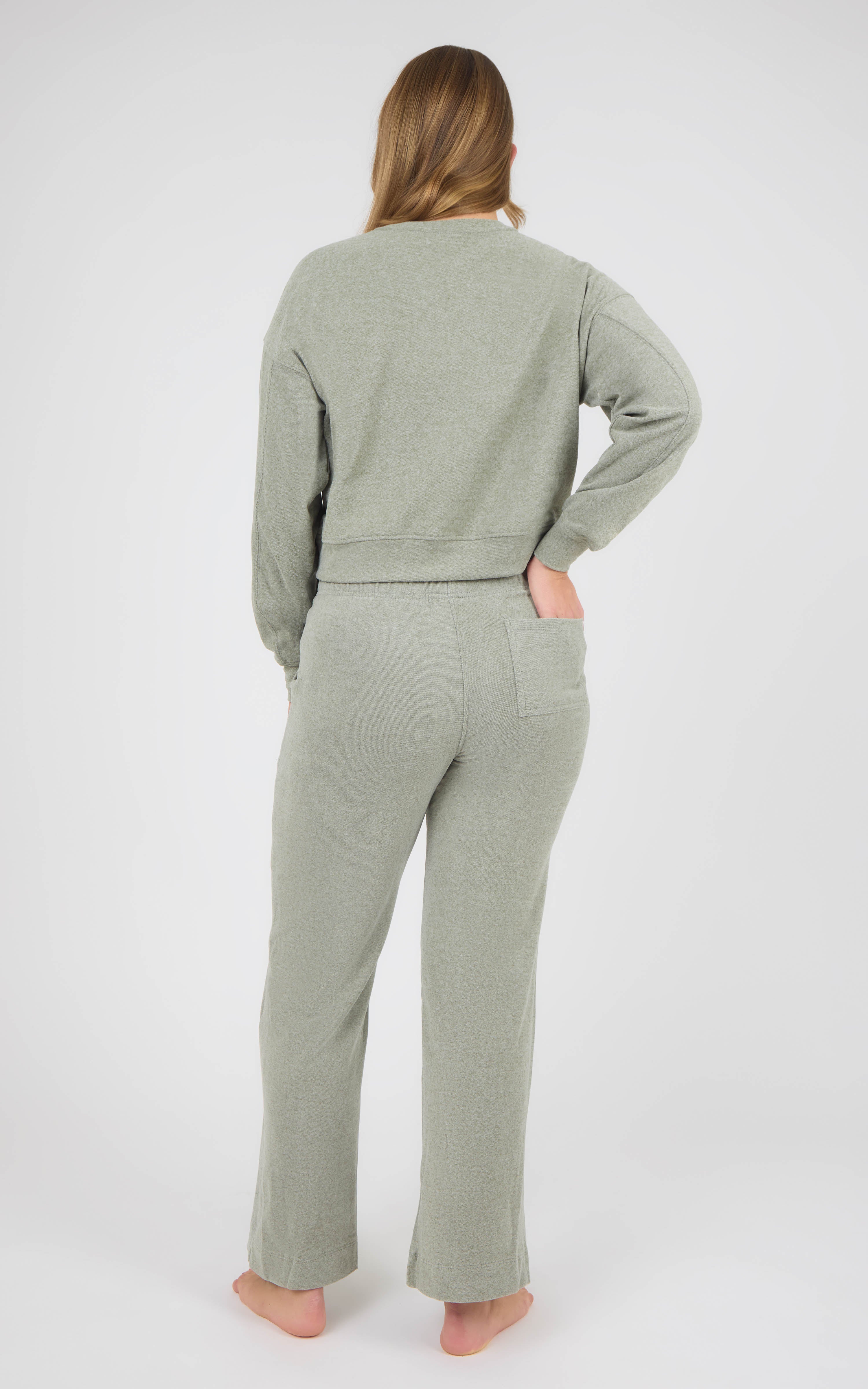 Model wearing a sage gray marled crewneck pullover and matching wide-leg pants, shown from behind.
