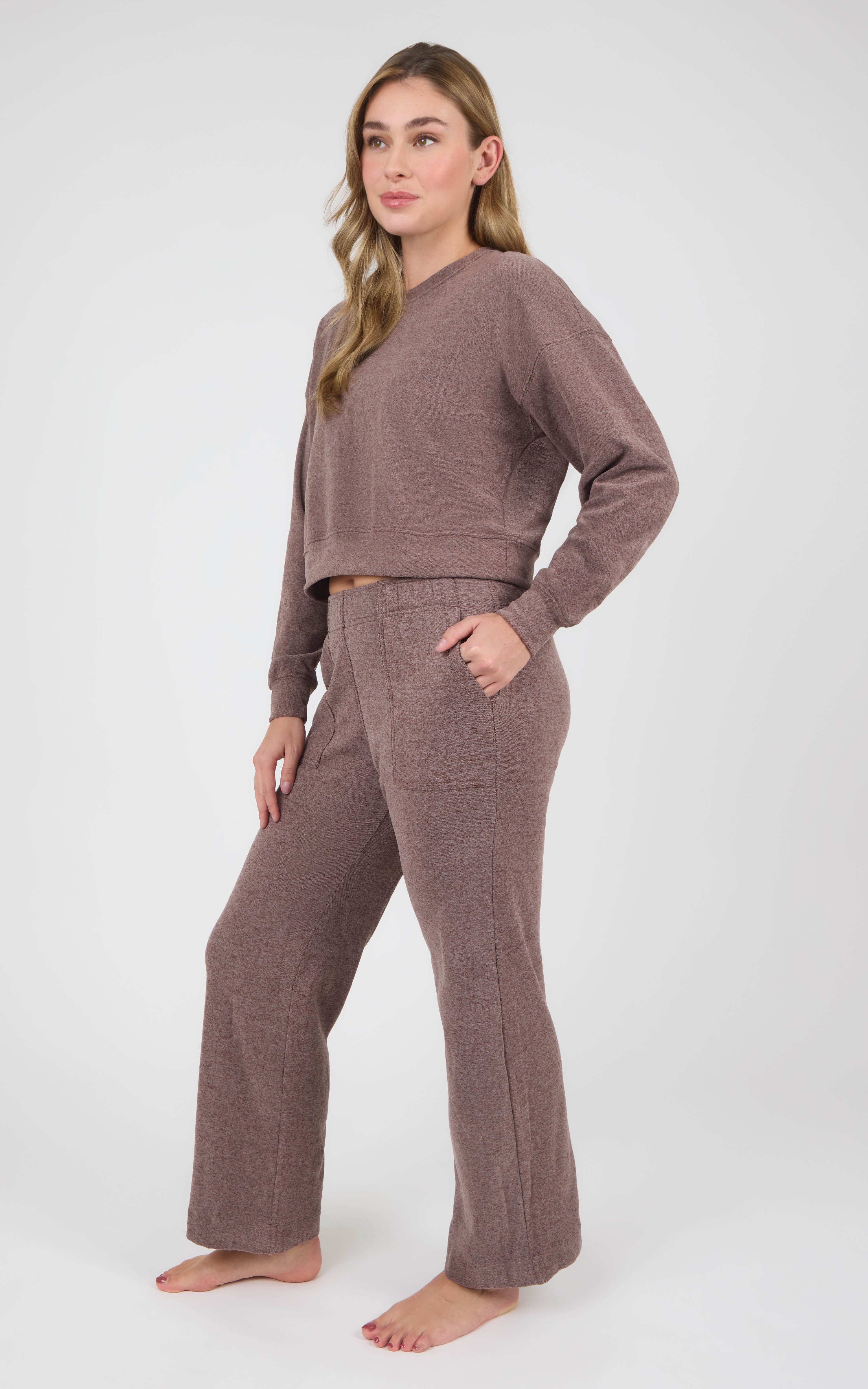 Woman wearing a taupe marled long-sleeve crewneck and matching wide-leg pants with side pockets.