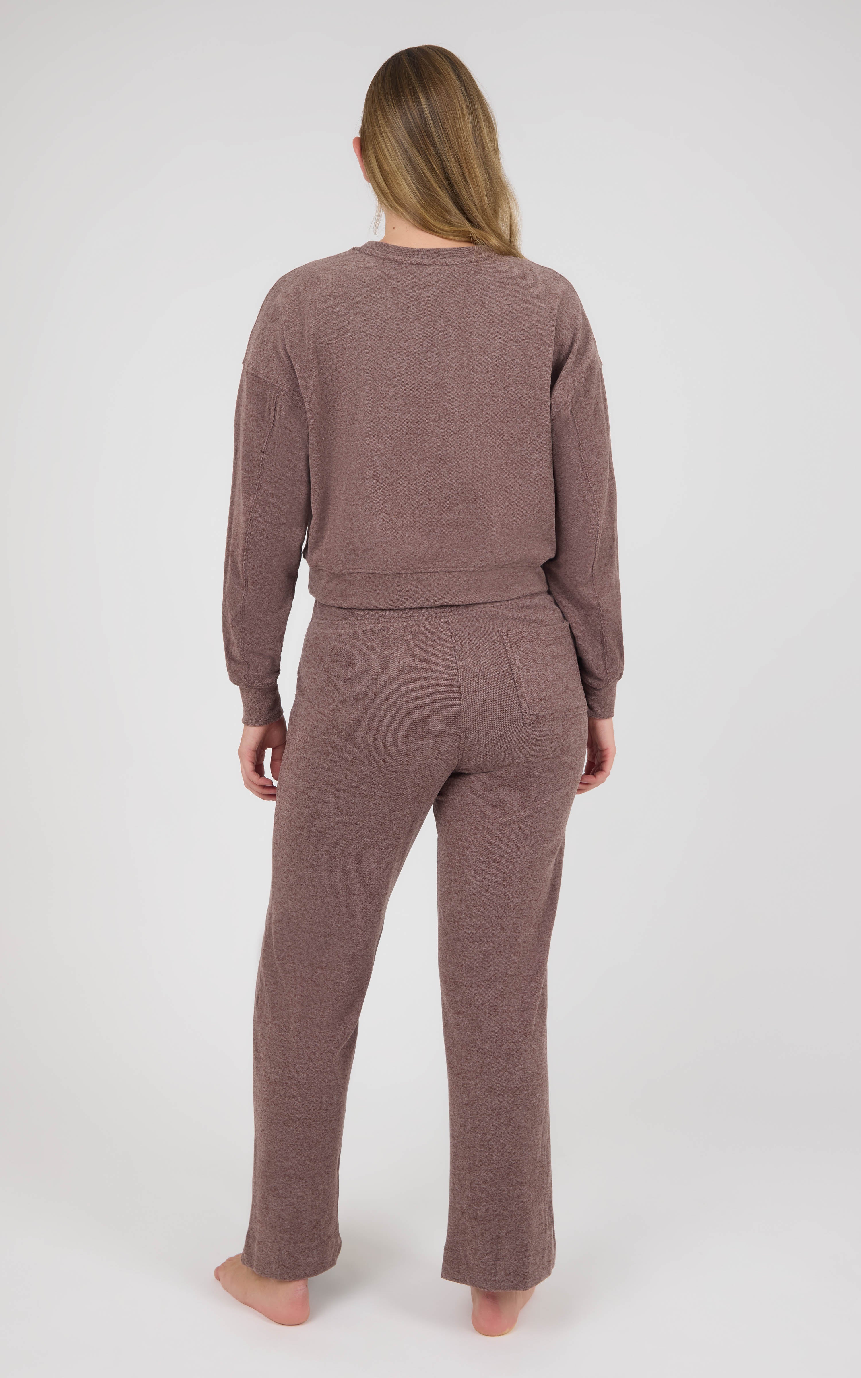 Back view of a model wearing a muted mauve marled knit lounge set with a long-sleeve crewneck pullover and wide-leg pants.
