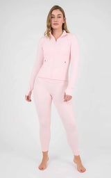 Woman wearing a pale pink fitted hooded jacket and matching ankle-length leggings with a smooth, stretchy finish.