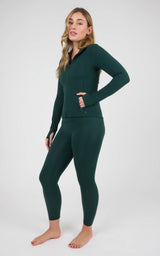 Model wearing a dark teal zip-front jacket and matching high-waisted ankle leggings with a sleek, fitted finish.