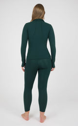 Woman modeling a dark forest-green matching set with a fitted long-sleeve zip jacket and ankle-length leggings, shown from.
